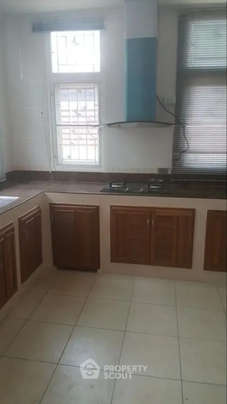 Spacious kitchen with modern gas stove and ample cabinetry in a bright, airy setting.