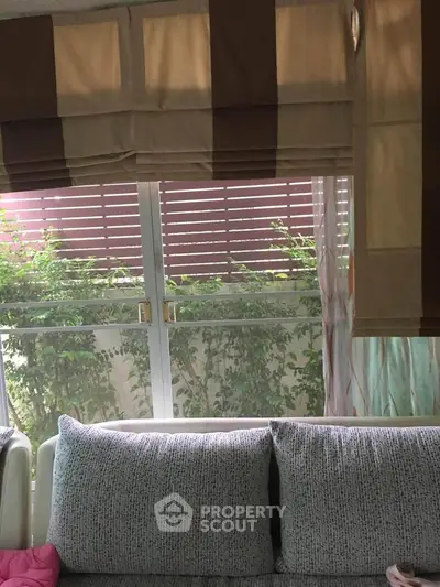 Cozy living room with large window and stylish curtains, perfect for natural light.