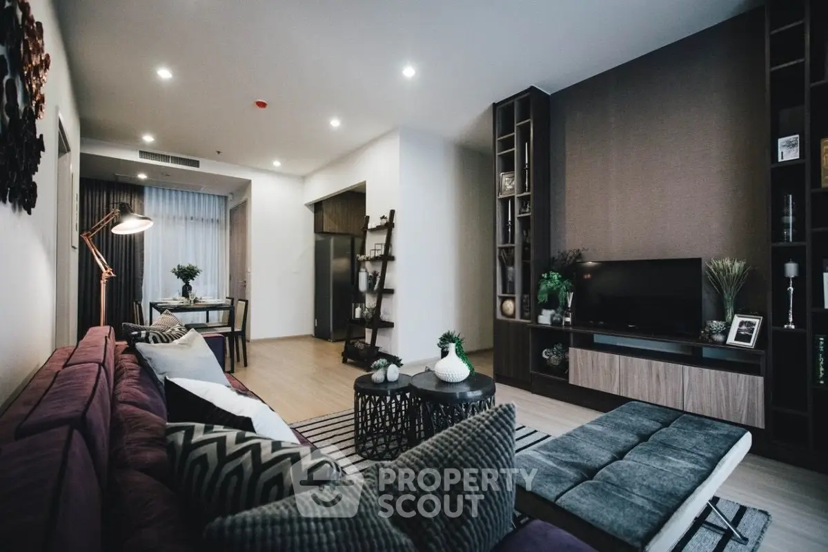 Modern living room with stylish decor and open layout, featuring a cozy seating area and elegant lighting.