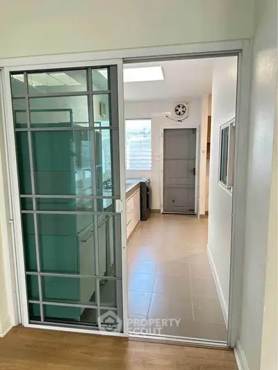 Modern kitchen with sliding glass door and sleek tile flooring