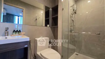 Modern bathroom with sleek design, glass shower, and elegant fixtures in a contemporary apartment.