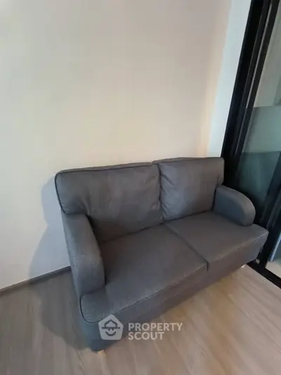 Cozy gray sofa in a modern living room with wooden flooring