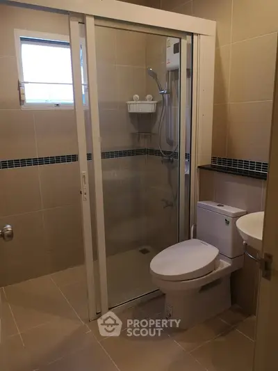 Modern bathroom with glass shower enclosure and sleek fixtures.