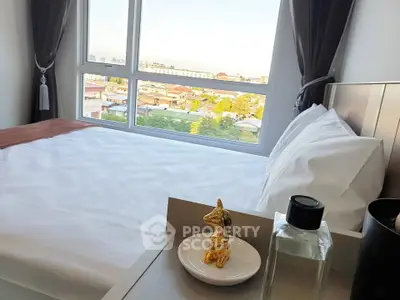 Modern bedroom with large window offering stunning city view and elegant decor.