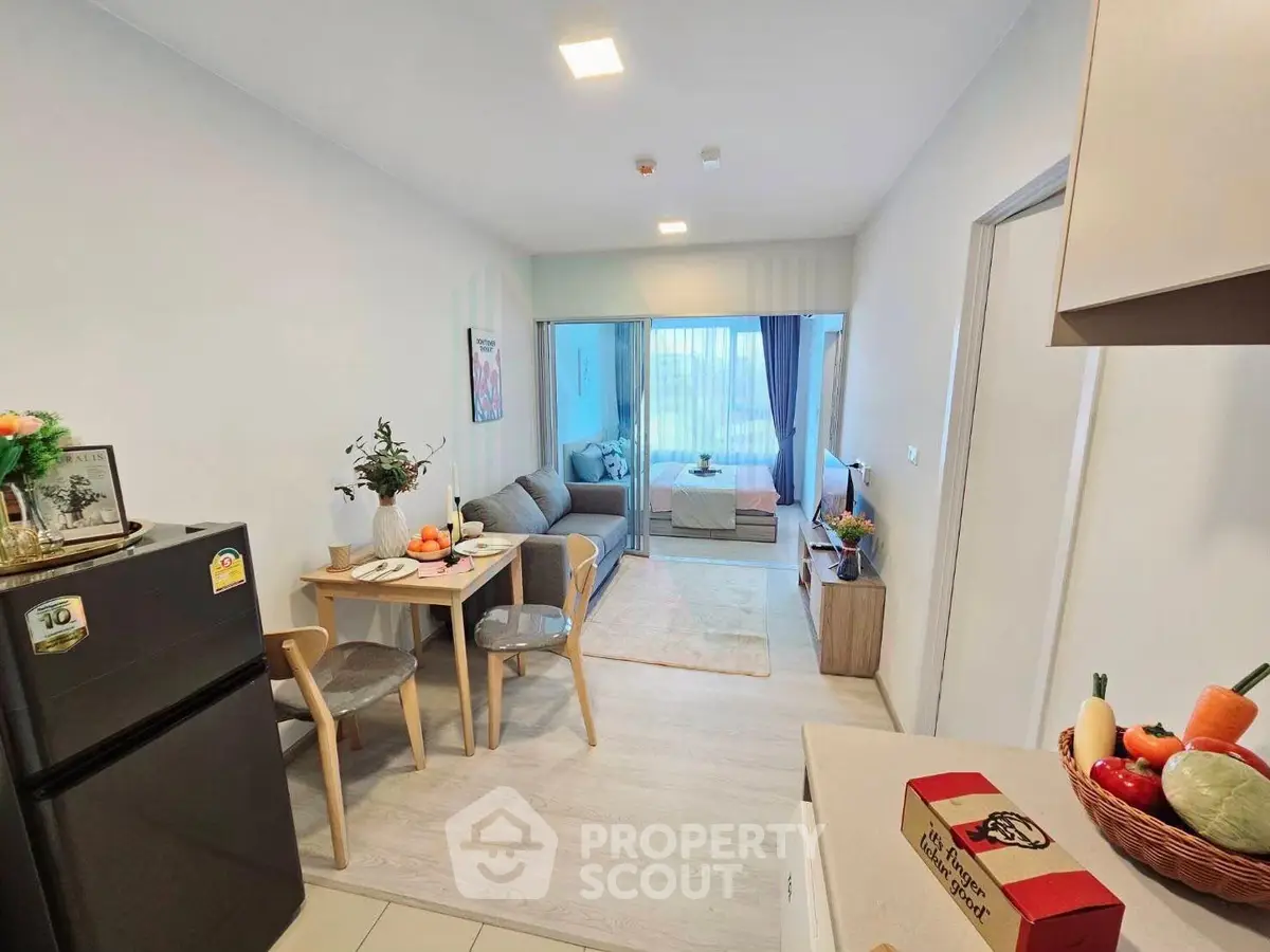Modern open-plan living room with dining area and cozy bedroom in a stylish apartment.
