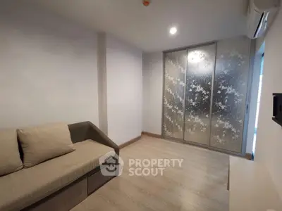 Modern minimalist living room with stylish sofa and floral sliding door wardrobe.