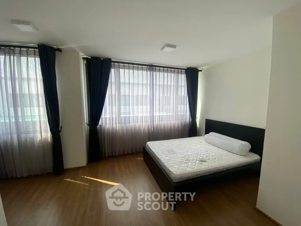 Spacious bedroom with large windows and natural light