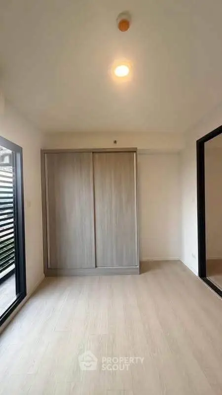 Spacious bedroom with sliding closet doors and large windows for natural light.
