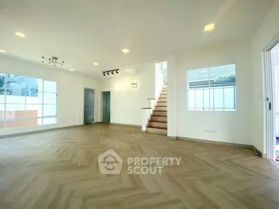 Spacious modern living room with elegant staircase and large windows
