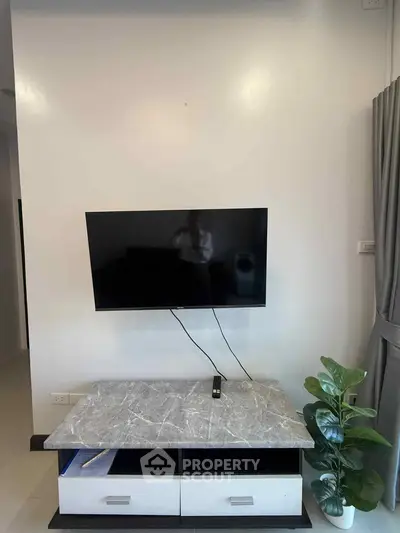 Modern living room with wall-mounted TV and stylish marble-top console