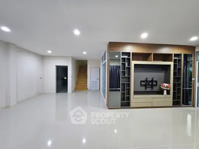 Spacious modern living room with sleek tile flooring and built-in entertainment center.
