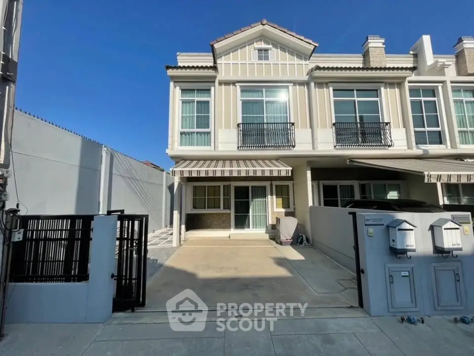 Charming two-story townhouse with modern facade and spacious driveway in a serene neighborhood.