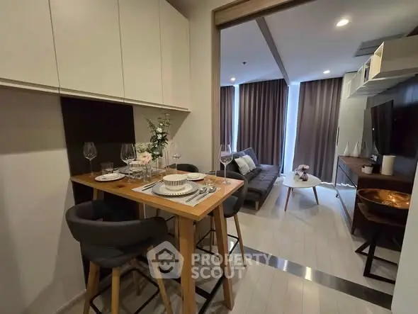 Modern open-plan living room with dining area, featuring stylish furniture and elegant decor.
