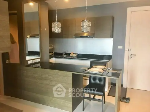Modern kitchen with sleek design and dining area in stylish apartment.