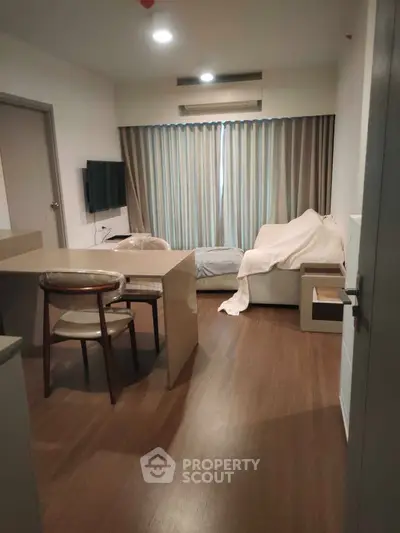 Cozy living room with modern furniture and wooden flooring, perfect for relaxation.