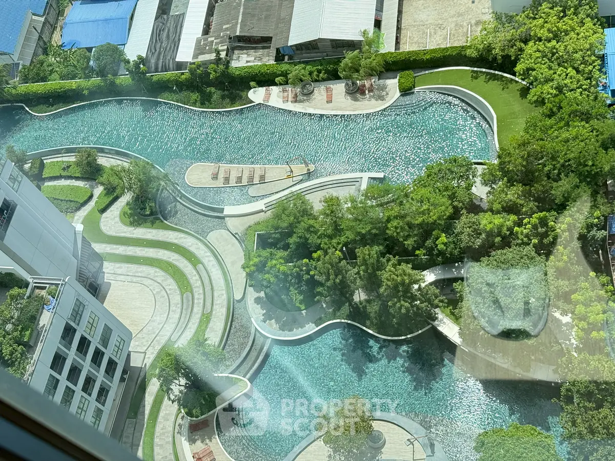 Stunning aerial view of luxurious pool and landscaped garden in modern residential complex.