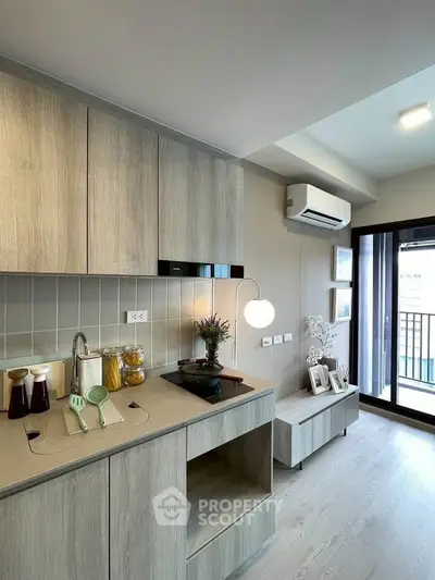Modern kitchen with sleek cabinetry and balcony access in stylish apartment