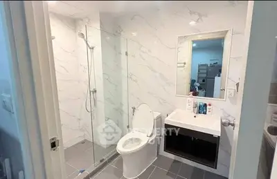 Modern bathroom with glass shower and sleek fixtures in a contemporary apartment.