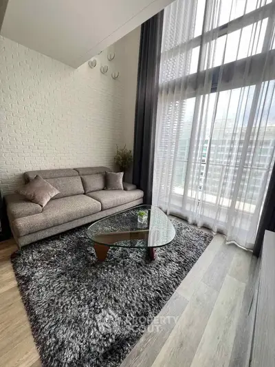 Modern living room with high ceilings, large windows, and stylish furniture in a luxury apartment.