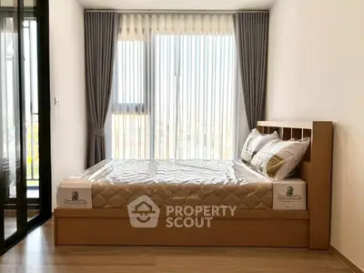 Modern bedroom with large window and stylish curtains, featuring a comfortable bed and sleek wooden flooring.
