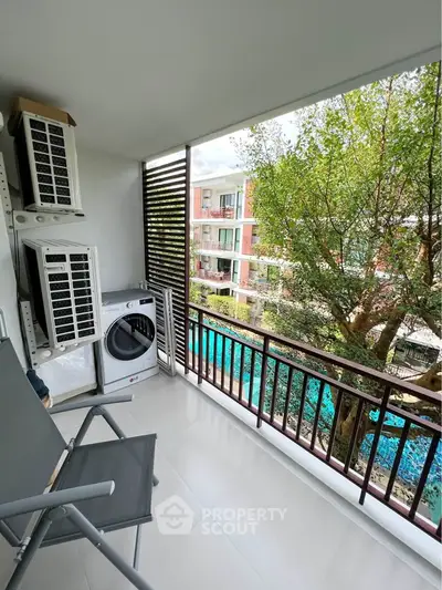 Charming balcony with pool view, featuring outdoor seating and modern appliances, perfect for relaxation.