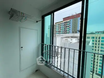 Modern balcony with city view and laundry rack in high-rise apartment