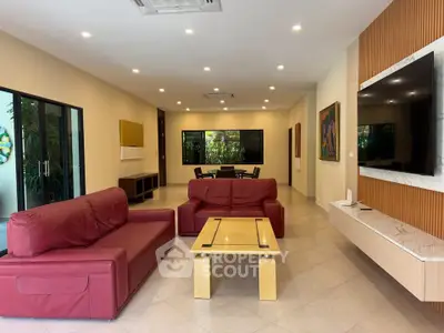 Spacious living room with modern red sofas and wall-mounted TV, perfect for family gatherings.