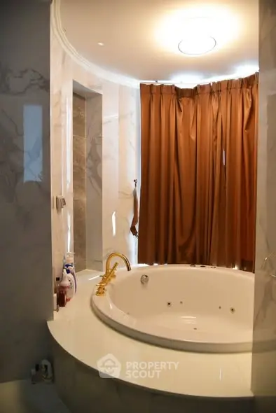 Luxurious bathroom with elegant marble finishes and a round bathtub, perfect for relaxation.