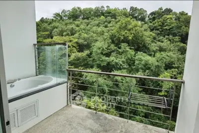 Stunning balcony with lush forest view and outdoor bathtub, perfect for relaxation.