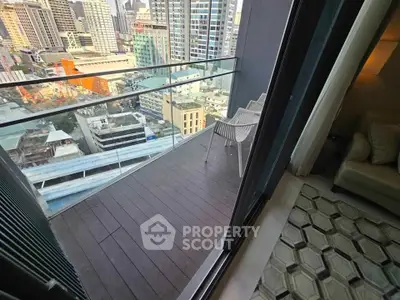 Stunning city view from a modern high-rise balcony with stylish seating, perfect for urban living.