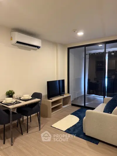Modern living room with sleek furniture and open layout, featuring a cozy dining area and stylish decor.