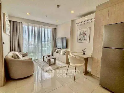 Modern living room with open layout, featuring sleek furniture and large windows for natural light.