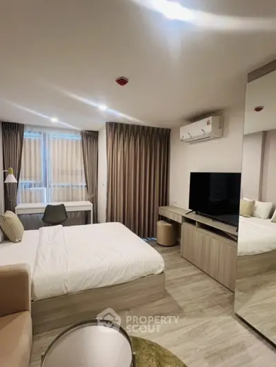 Modern bedroom with sleek design, featuring a large mirror, TV, and stylish furnishings.