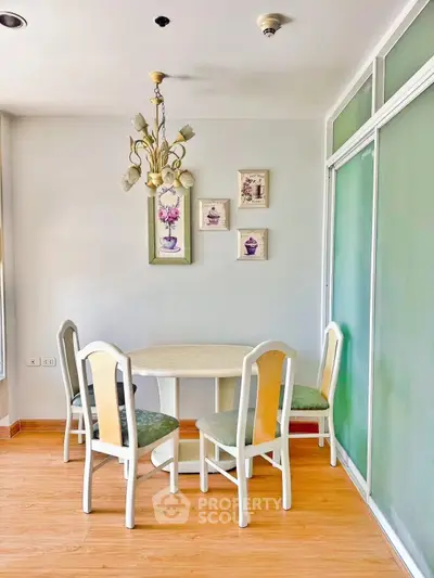 Charming dining area with elegant chandelier and stylish decor in a cozy apartment.