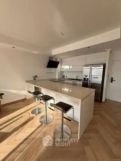 Modern kitchen with sleek design, island seating, and stainless steel appliances