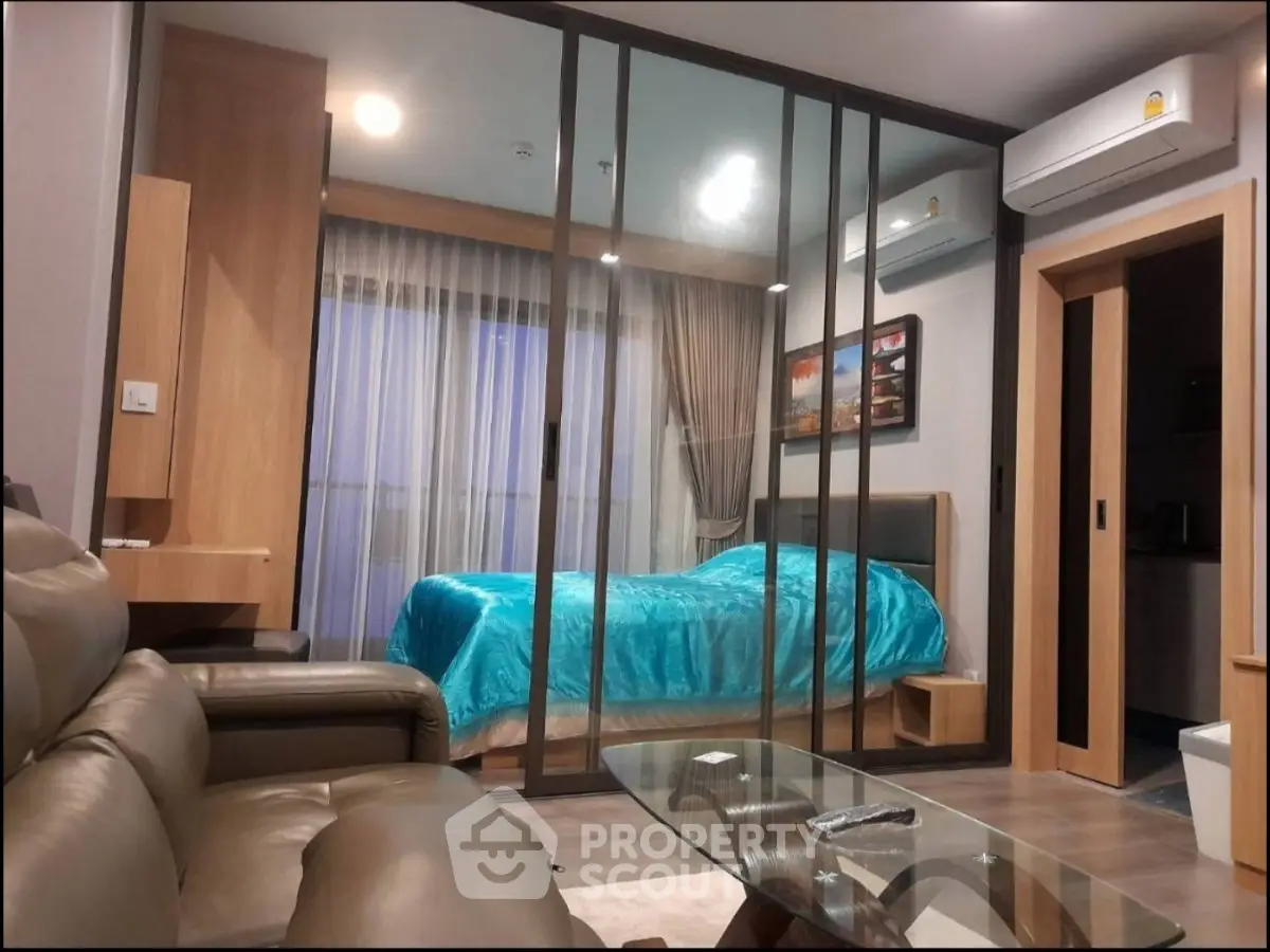 Modern living room with glass partition and cozy bedroom view