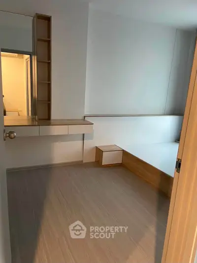 Minimalist bedroom with built-in furniture and wooden flooring