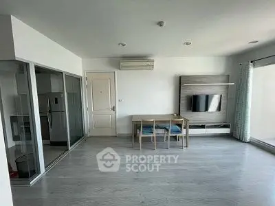 Modern living room with sleek design and open layout, featuring a wall-mounted TV and dining area.