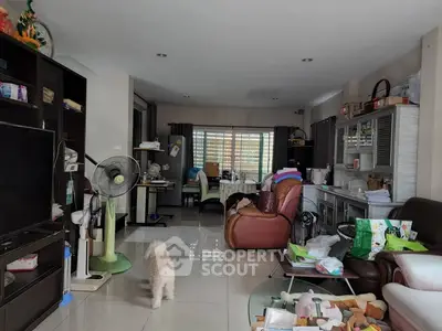 Spacious living room with modern furniture and open layout, featuring a cozy atmosphere and ample natural light.