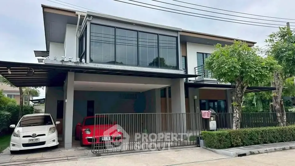 Modern two-story house with spacious driveway and sleek design in a suburban neighborhood.