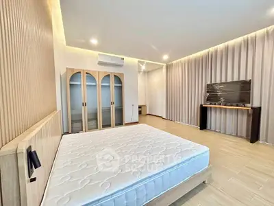 Spacious bedroom with modern design and ample natural light, featuring a large wardrobe and sleek flooring.