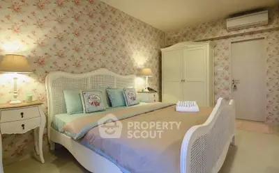 Charming bedroom with floral wallpaper and elegant white furniture, perfect for a cozy retreat.