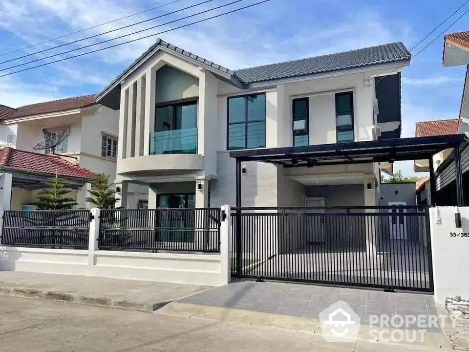 Modern two-story house with sleek design and spacious driveway in suburban neighborhood.