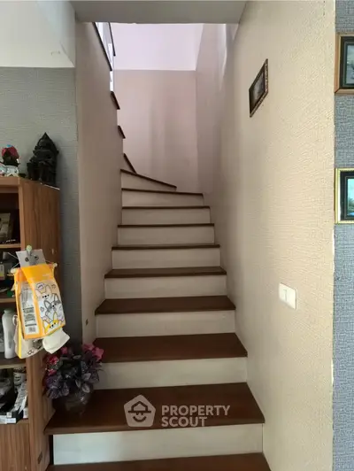 Charming staircase with wooden steps and decorative accents in a cozy home interior.