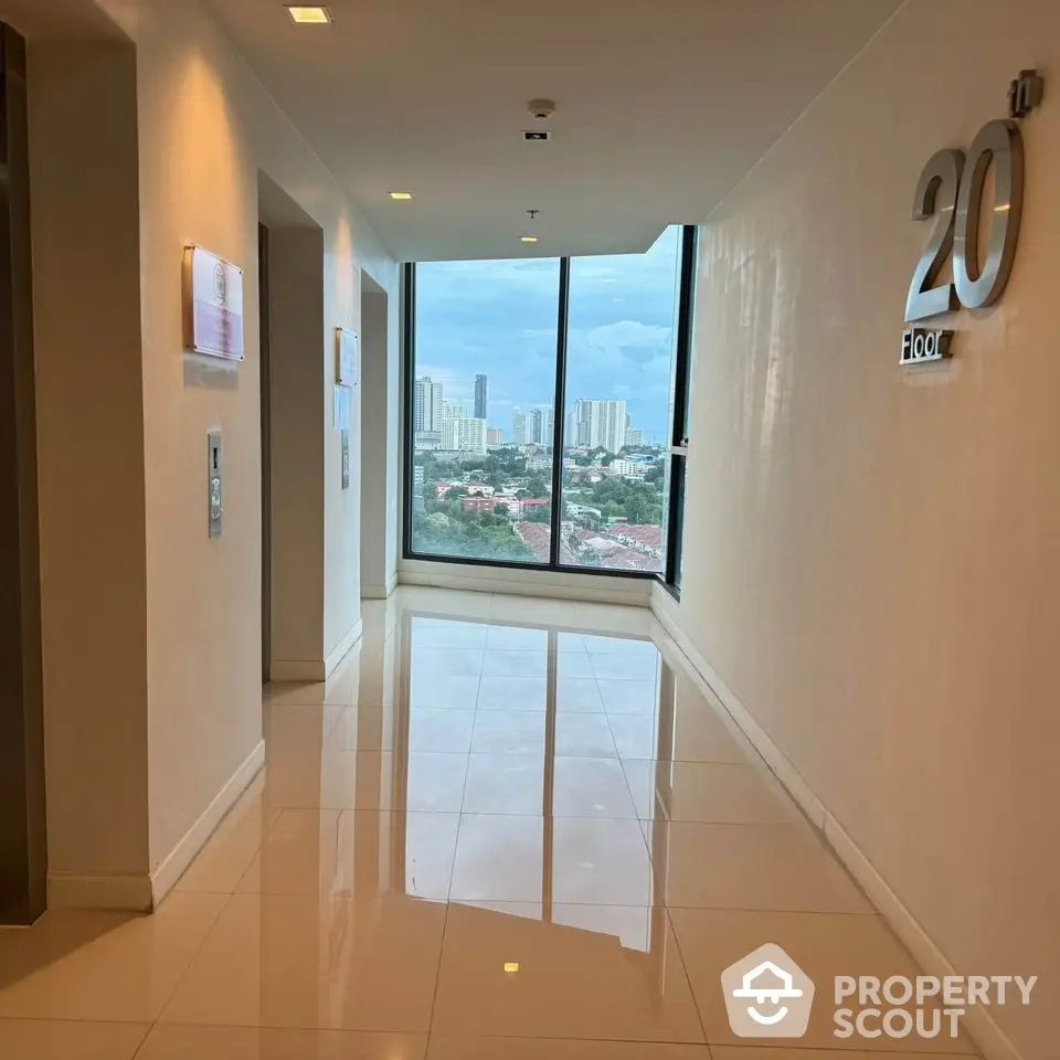 Modern high-rise building hallway with city view from the 20th floor.