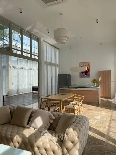 Spacious living room with high ceilings, modern furniture, and large windows for natural light.