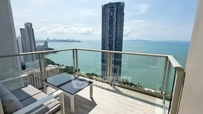 Stunning high-rise balcony with panoramic ocean views and modern seating area.