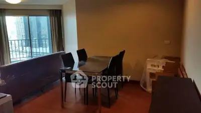 Modern living room with dining area and balcony view in urban apartment.