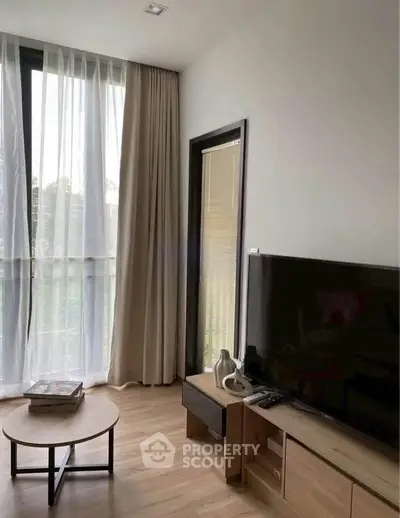 Modern living room with large window and stylish furniture, perfect for relaxation and entertainment.