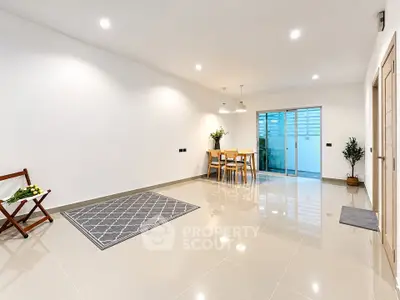 Spacious modern living room with glossy tiled floors and elegant dining area.